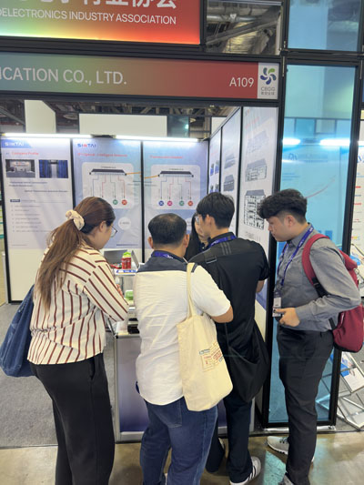 Attendees gathered at the Sintai Communication Co., Ltd. trade show booth, talking with staff and examining product displays-01. Attendees gathered at the Sintai Communication Co., Ltd. trade show booth, talking with staff and examining product displays-01.